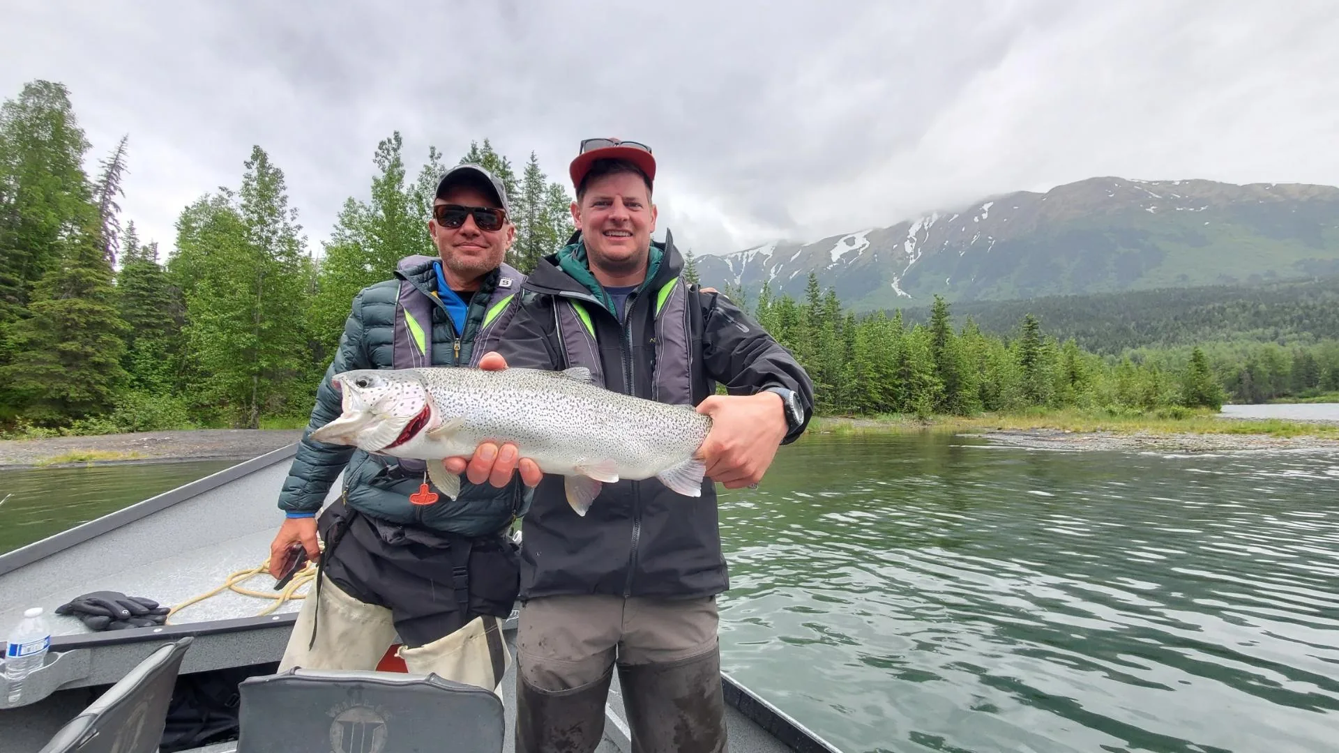 Two anglers holding a large rainbow trout on a Cooper Landing fly fishing trip, Kenai River